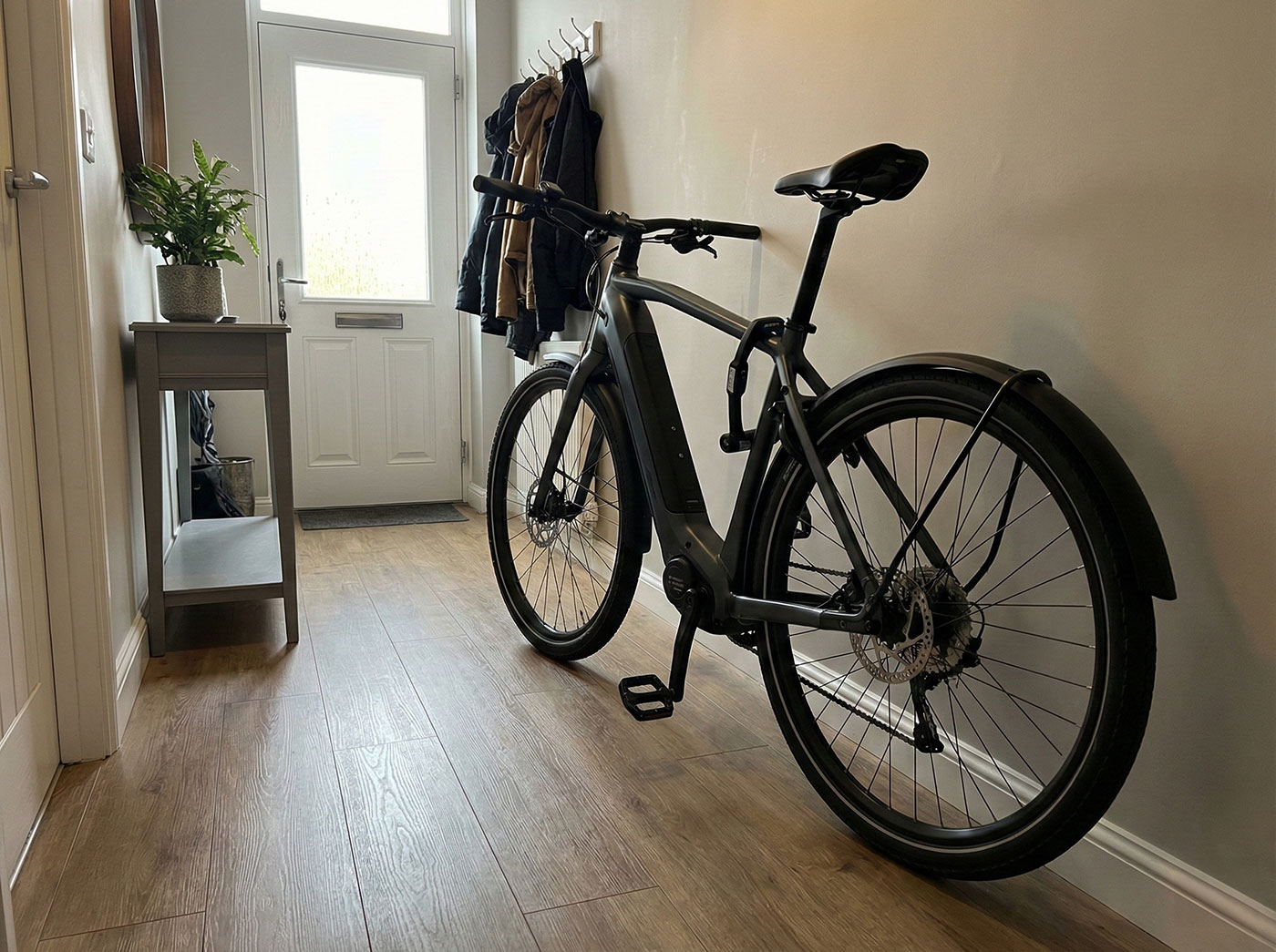 A sleek electric bicycle stored securely in the hallway of a modern home, representing high-value personal possessions that require specialist cover on a home insurance policy.