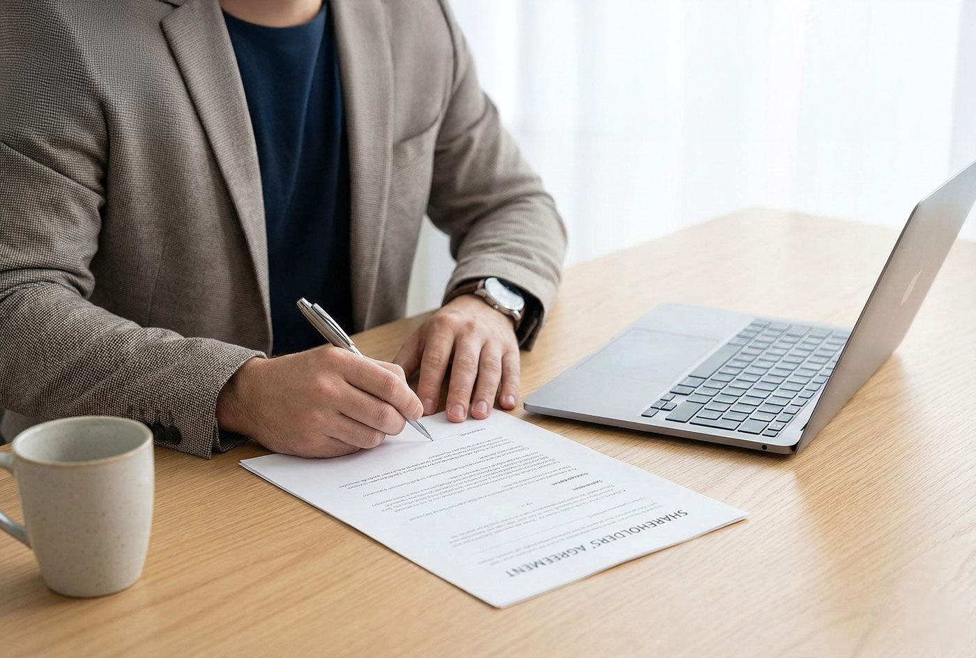A close-up of hands signing a formal legal document on a bright, modern desk, representing the cross-option agreement that secures business ownership.